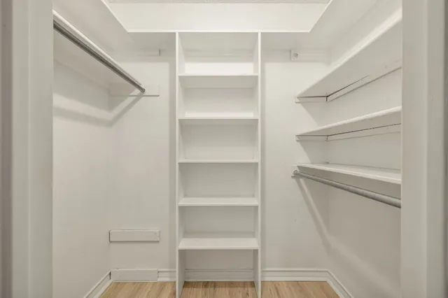 a view of walk in closet with empty racks