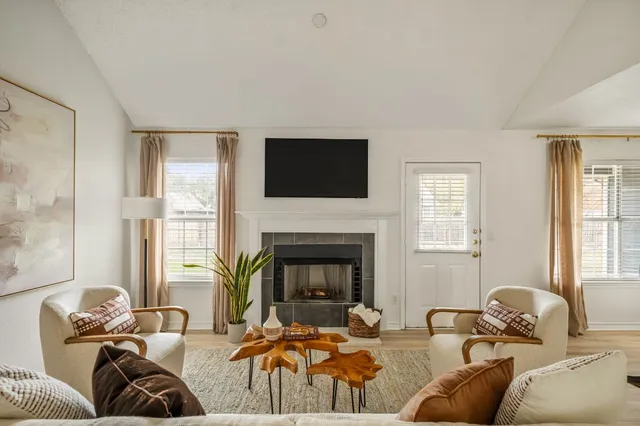 a living room with furniture a fireplace and a flat screen tv