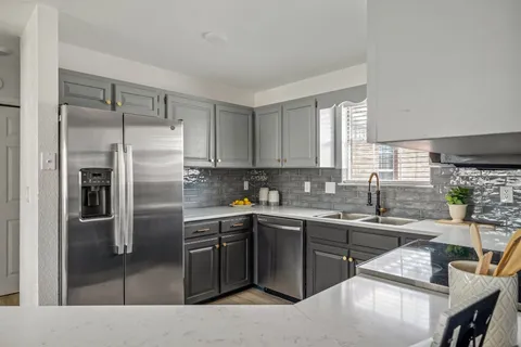 a kitchen with a sink a counter top space stainless steel appliances and cabinets