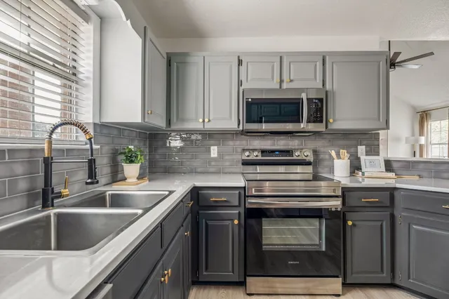a kitchen with granite countertop a stove sink and microwave
