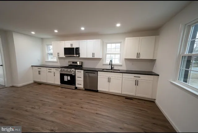 a kitchen with stainless steel appliances granite countertop a sink and cabinets