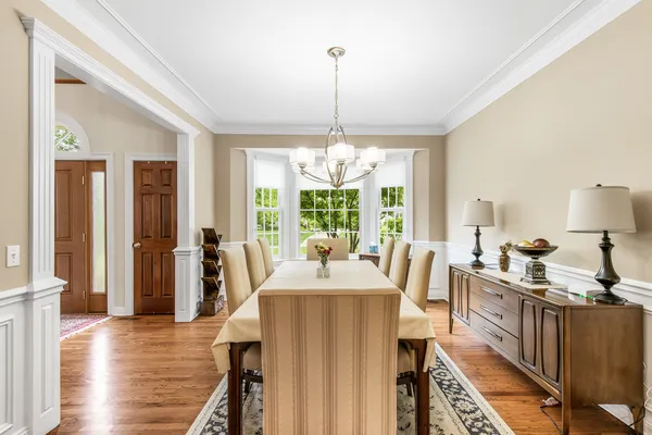 a view of a dining room with furniture a chandelier and wooden floor