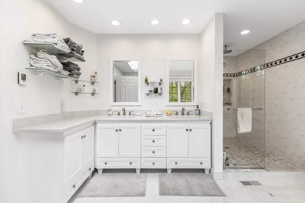 a white bath tub sitting in a spacious bathroom next to a window