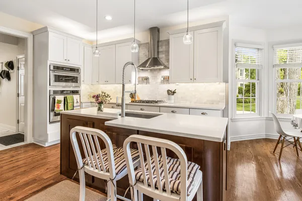a kitchen with stainless steel appliances granite countertop a sink a stove and a wooden floors