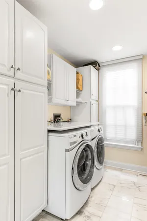 a large kitchen with kitchen island white cabinets and stainless steel appliances