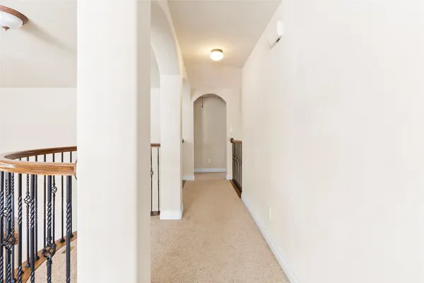 a view of a hallway with wooden floor and stairs