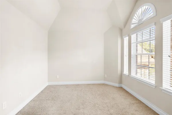 an empty room with windows and fireplace