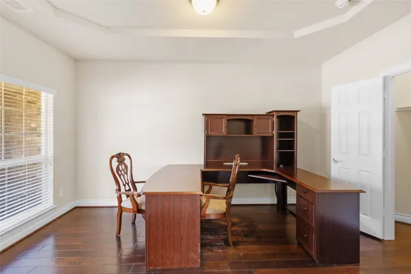 a view of a workspace with furniture and a window