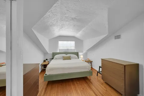 a bedroom with a bed and wooden floor