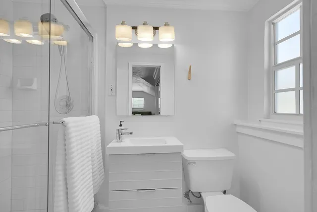 a bathroom with a sink vanity mirror and toilet
