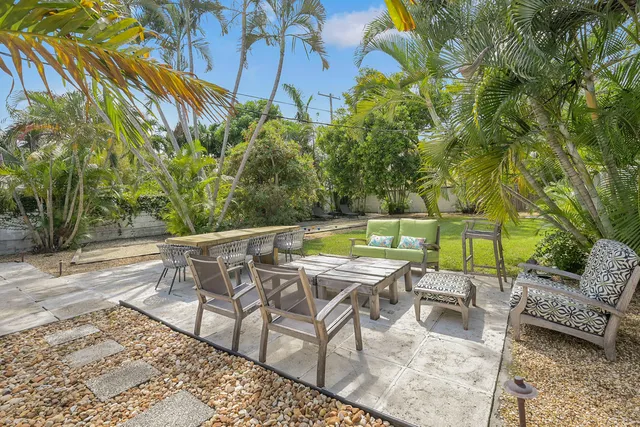 a patio with glass top table and chairs