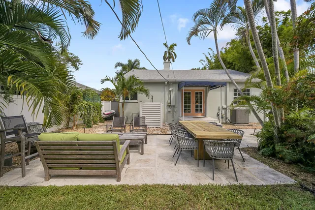 a view of a chair and table in backyard of the house