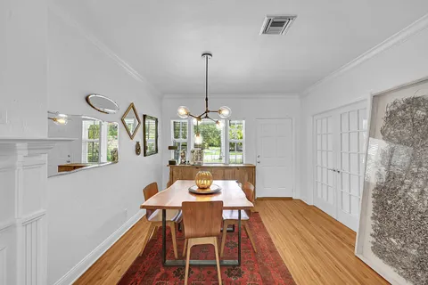 a dining room with furniture a chandelier and wooden floor