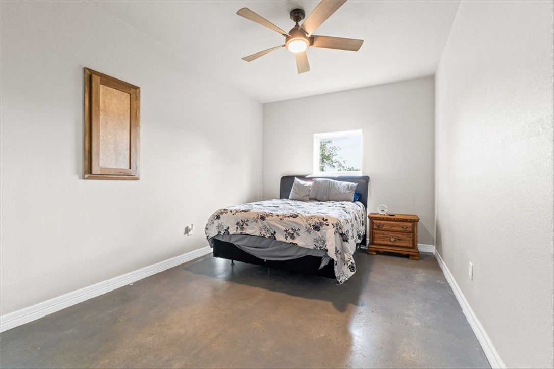207 South Charles Street George West, TX 78022 - Photo 19 of 24 a bedroom with a bed and a chandelier