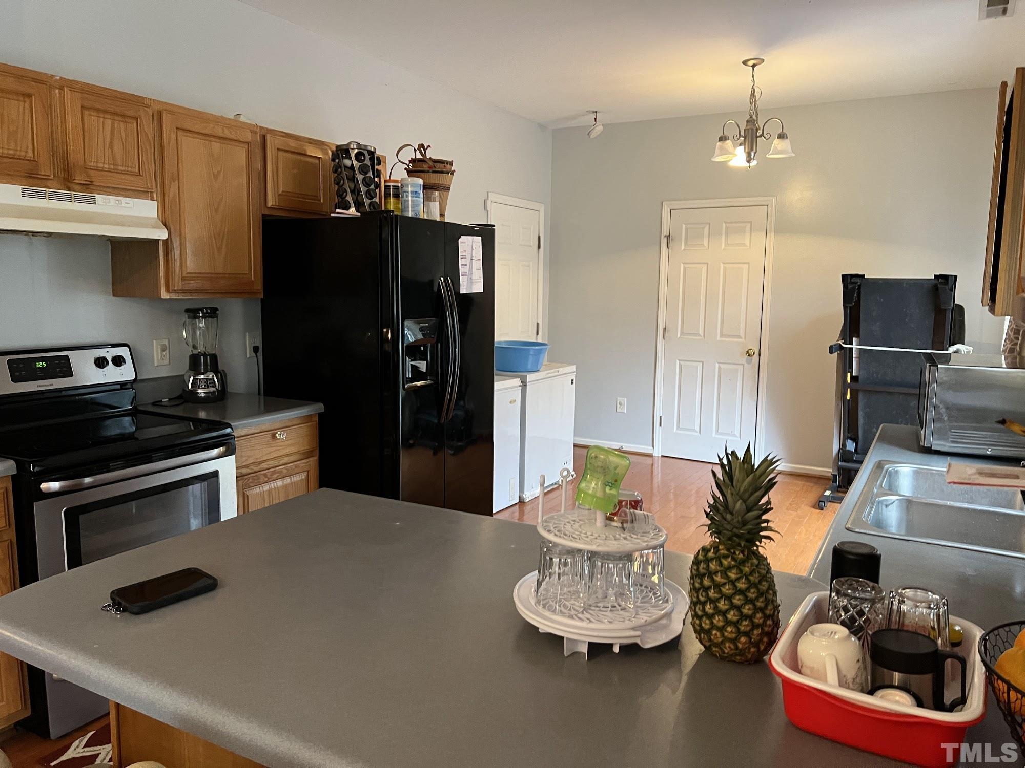 4109 Bay Rum Lane Raleigh, NC 27610 - Photo 17 of 31 a kitchen with a refrigerator and a stove top oven