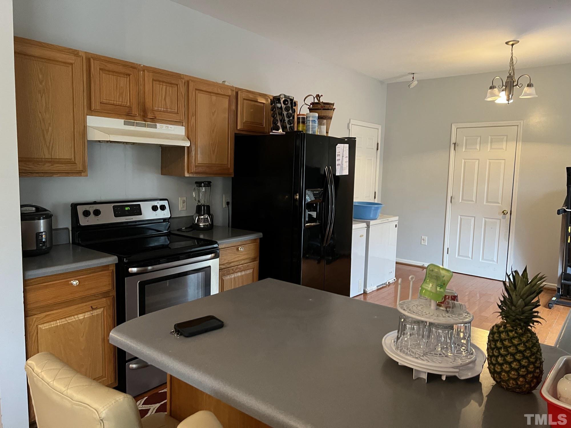 4109 Bay Rum Lane Raleigh, NC 27610 - Photo 18 of 31 a kitchen with a refrigerator and a stove top oven