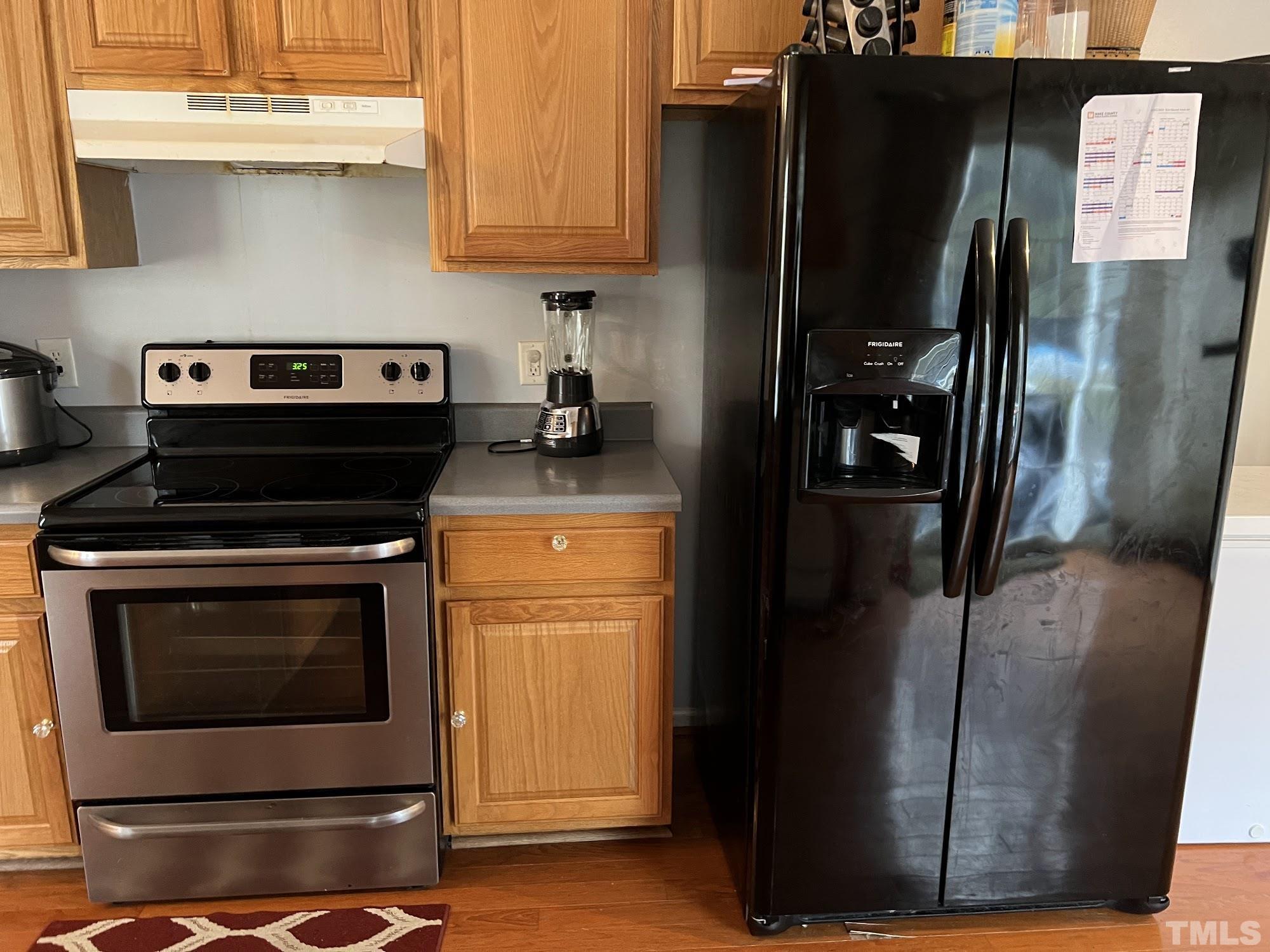 4109 Bay Rum Lane Raleigh, NC 27610 - Photo 20 of 31 a kitchen with a refrigerator stove and cabinets