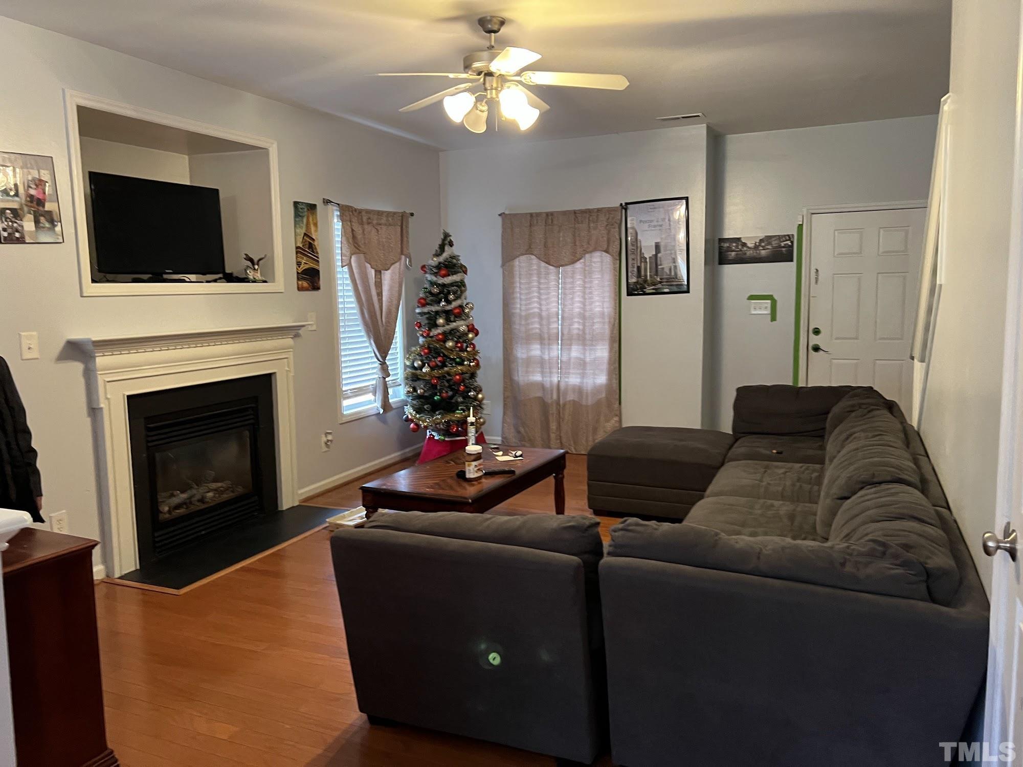 4109 Bay Rum Lane Raleigh, NC 27610 - Photo 24 of 31 a living room with furniture a fireplace and a flat screen tv