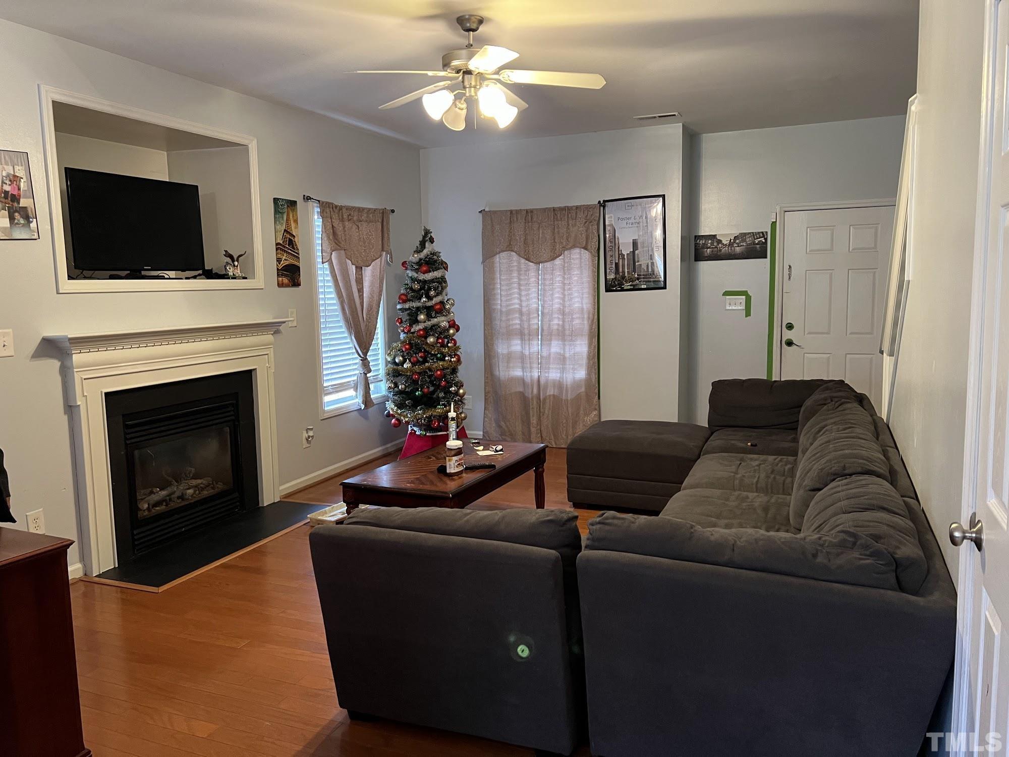 4109 Bay Rum Lane Raleigh, NC 27610 - Photo 25 of 31 a living room with furniture a flat screen tv and a fireplace