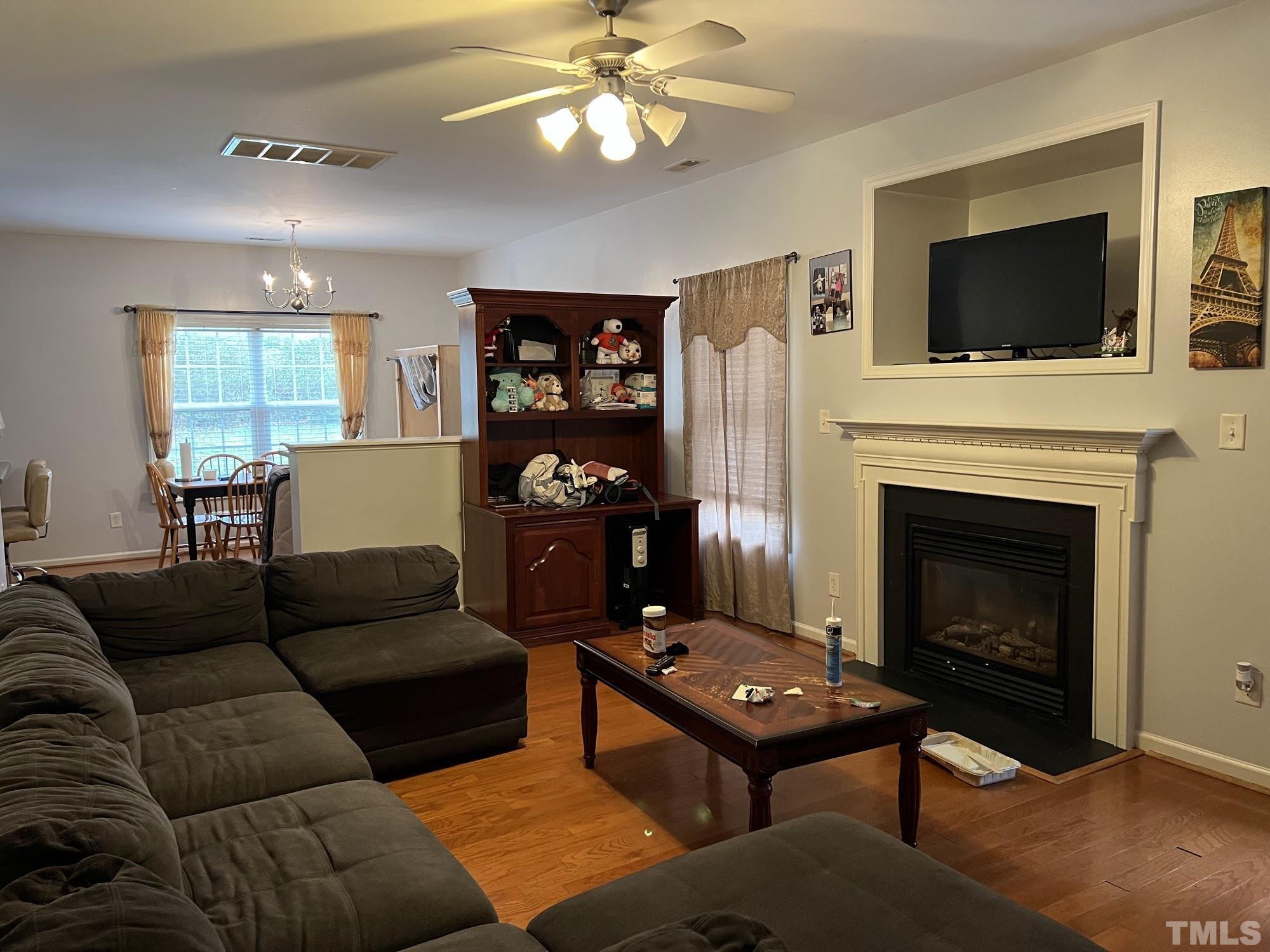 4109 Bay Rum Lane Raleigh, NC 27610 - Photo 29 of 31 a living room with furniture a flat screen tv and a fireplace