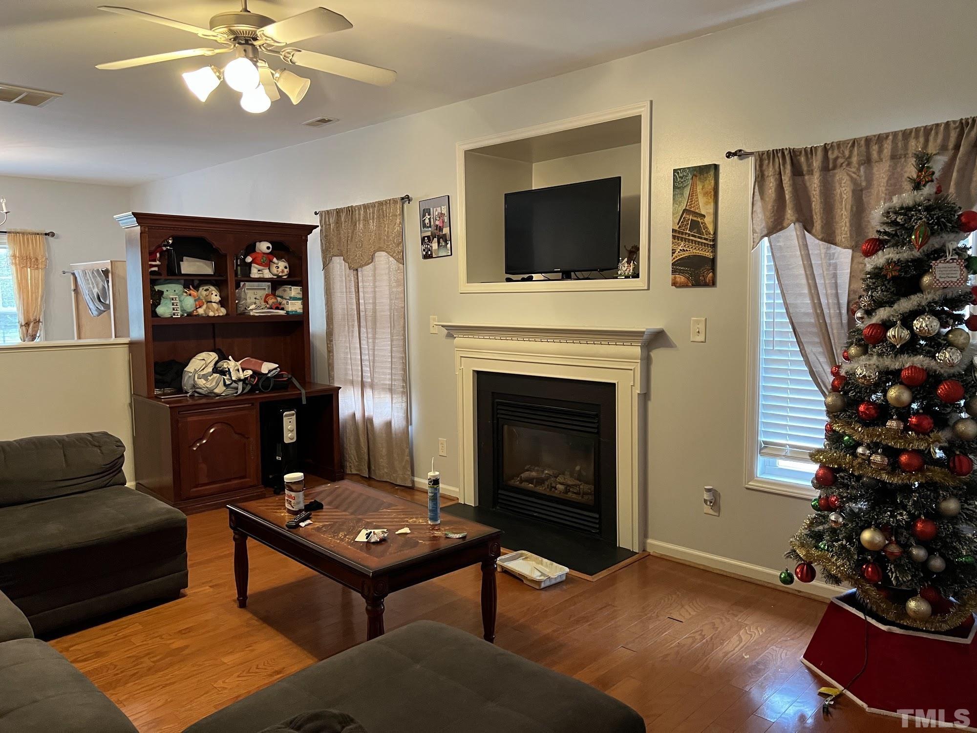4109 Bay Rum Lane Raleigh, NC 27610 - Photo 30 of 31 a living room with furniture a flat screen tv and a fireplace
