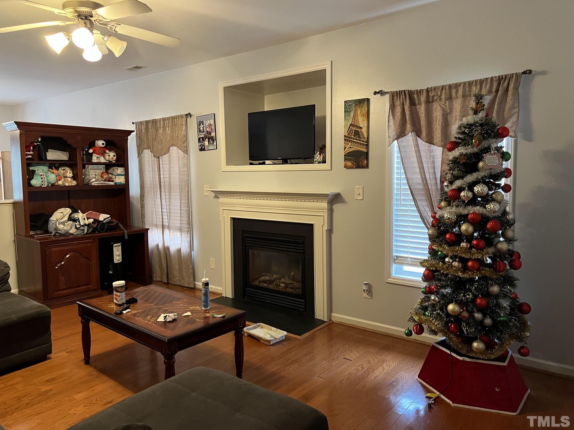 4109 Bay Rum Lane Raleigh, NC 27610 - Photo 31 of 31 a living room with furniture a flat screen tv and a fireplace