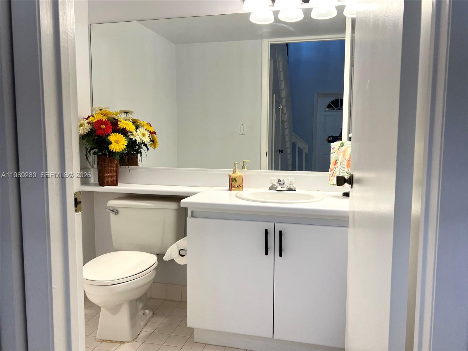 543 Racquet Club Road, Unit 33 Weston, FL 33326 - Photo 12 of 28 a bathroom with a sink mirror and toilet