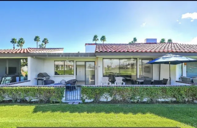 a front view of a house with a yard table and chairs