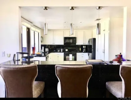 a dining room with furniture a large window and kitchen view