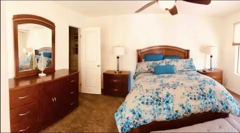 a bedroom with a bed and a dresser with mirror