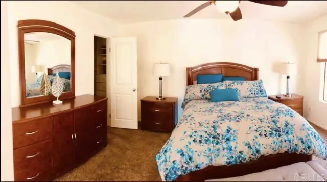 a bedroom with a bed and a dresser with mirror