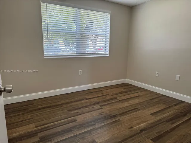 a view of a room with wooden floor and a window