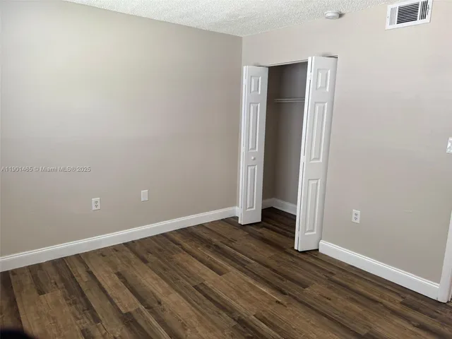 an empty room with wooden floor and closet