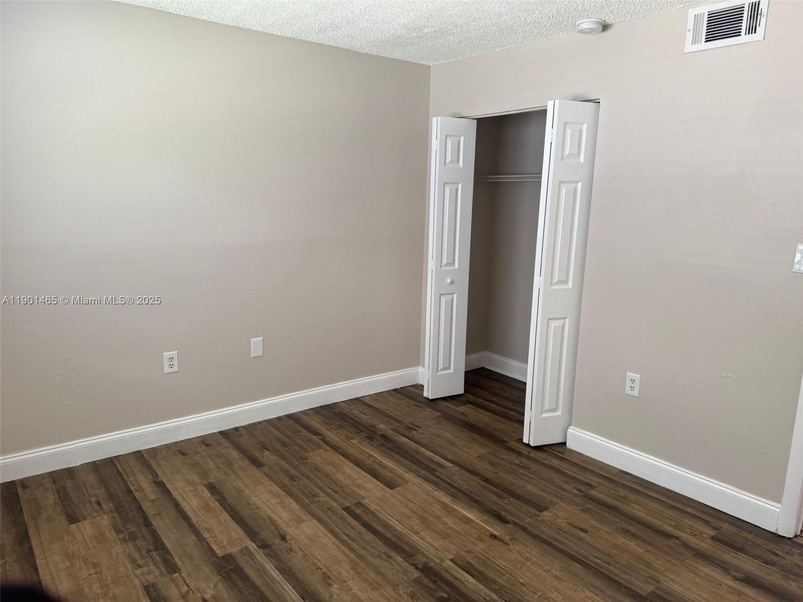2173 Southwest 80th Terrace, Unit 2173 Miramar, FL 33025 - Photo 18 of 31 an empty room with wooden floor and closet