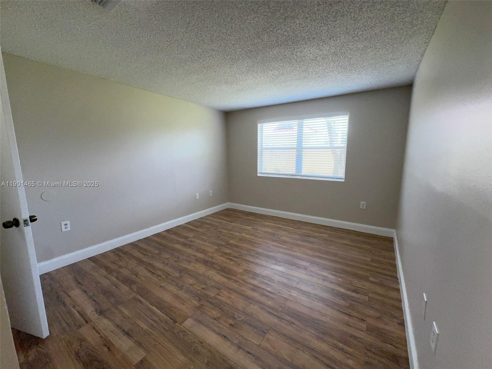 2173 Southwest 80th Terrace, Unit 2173 Miramar, FL 33025 - Photo 23 of 31 wooden floor in an empty room with a window