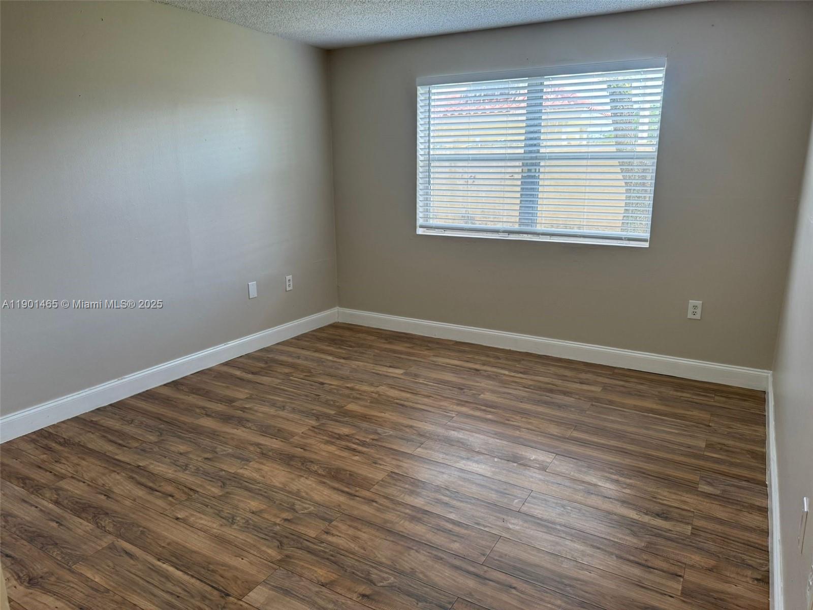 2173 Southwest 80th Terrace, Unit 2173 Miramar, FL 33025 - Photo 24 of 31 an empty room with wooden floor and windows