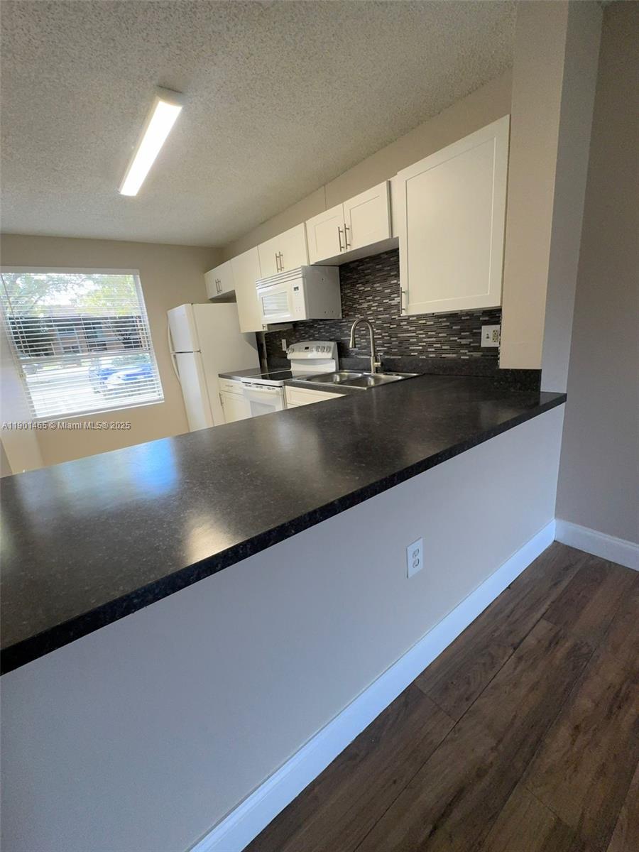 2173 Southwest 80th Terrace, Unit 2173 Miramar, FL 33025 - Photo 8 of 31 a view of a kitchen with kitchen island a sink dishwasher and a stove with wooden floor
