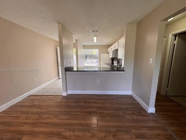 a view of a kitchen with wooden floor and electronic appliances
