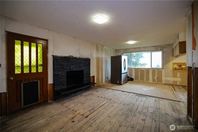a view of empty room with a fireplace and window