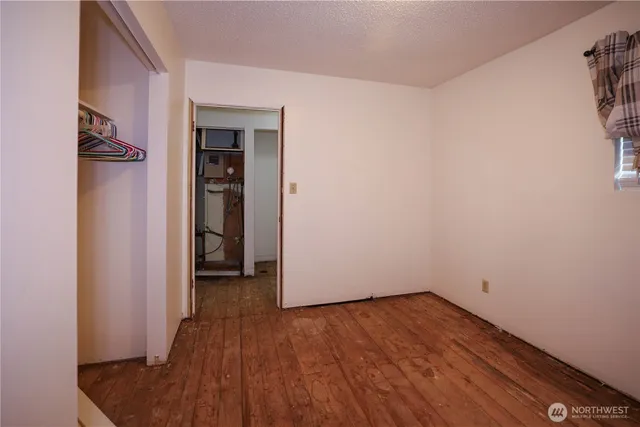 an empty room with wooden floor and closet