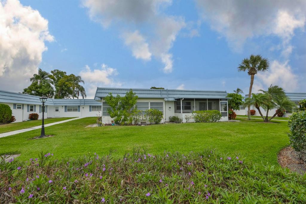1901 Andover Way, Unit 38 Sun City Center, FL 33573 - Photo 25 of 54 a front view of a house with a yard and porch