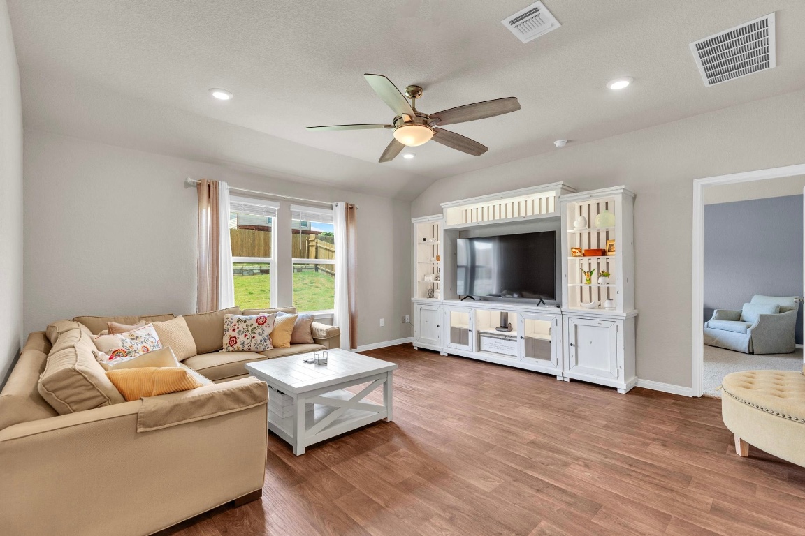 19525 Abigail Fillmore Road Manor, TX 78653 - Photo 15 of 40 Living area featuring wood finished floors, lofted ceiling, a ceiling fan, and recessed lighting