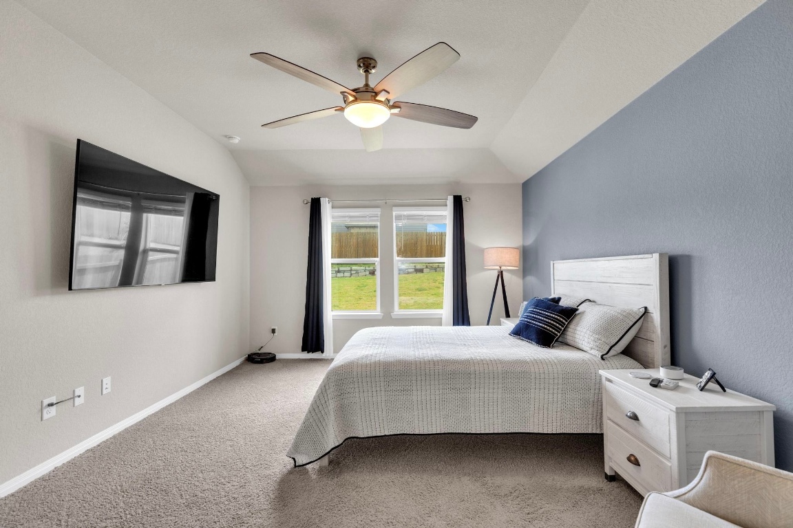 19525 Abigail Fillmore Road Manor, TX 78653 - Photo 19 of 40 Bedroom with carpet flooring, lofted ceiling, and a ceiling fan