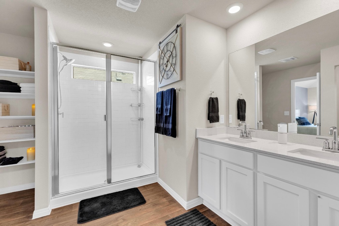 19525 Abigail Fillmore Road Manor, TX 78653 - Photo 21 of 40 Bathroom with a shower stall, double vanity, light wood finished floors, and ensuite bath