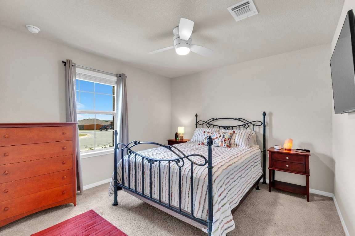 19525 Abigail Fillmore Road Manor, TX 78653 - Photo 27 of 40 Bedroom featuring light colored carpet and ceiling fan