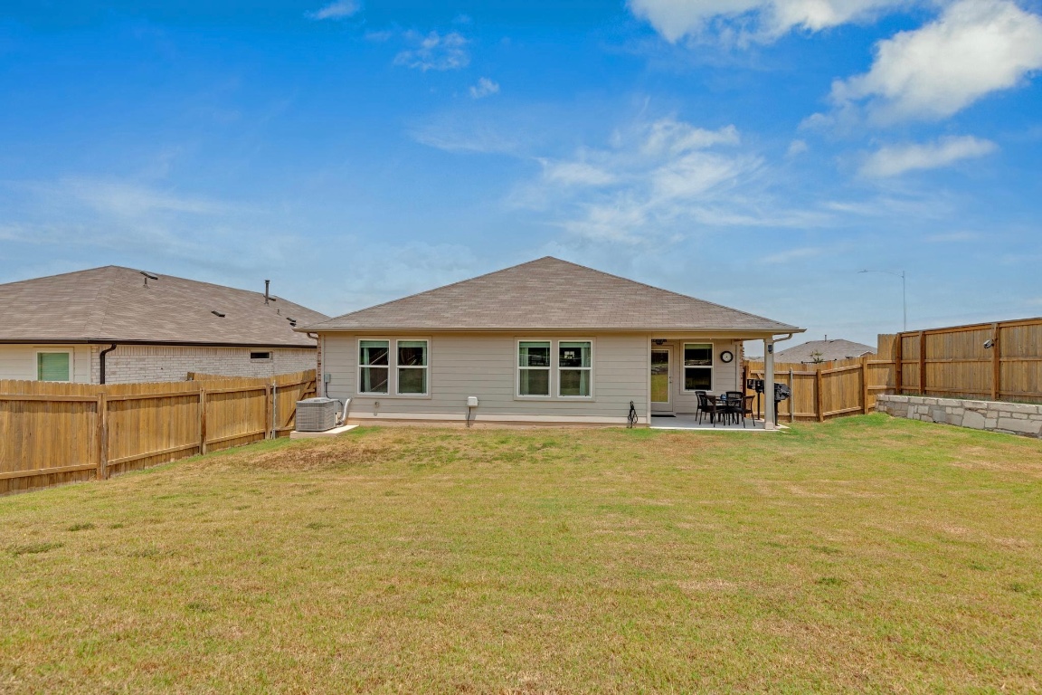 19525 Abigail Fillmore Road Manor, TX 78653 - Photo 31 of 40 Rear view of house with a patio area and a fenced backyard