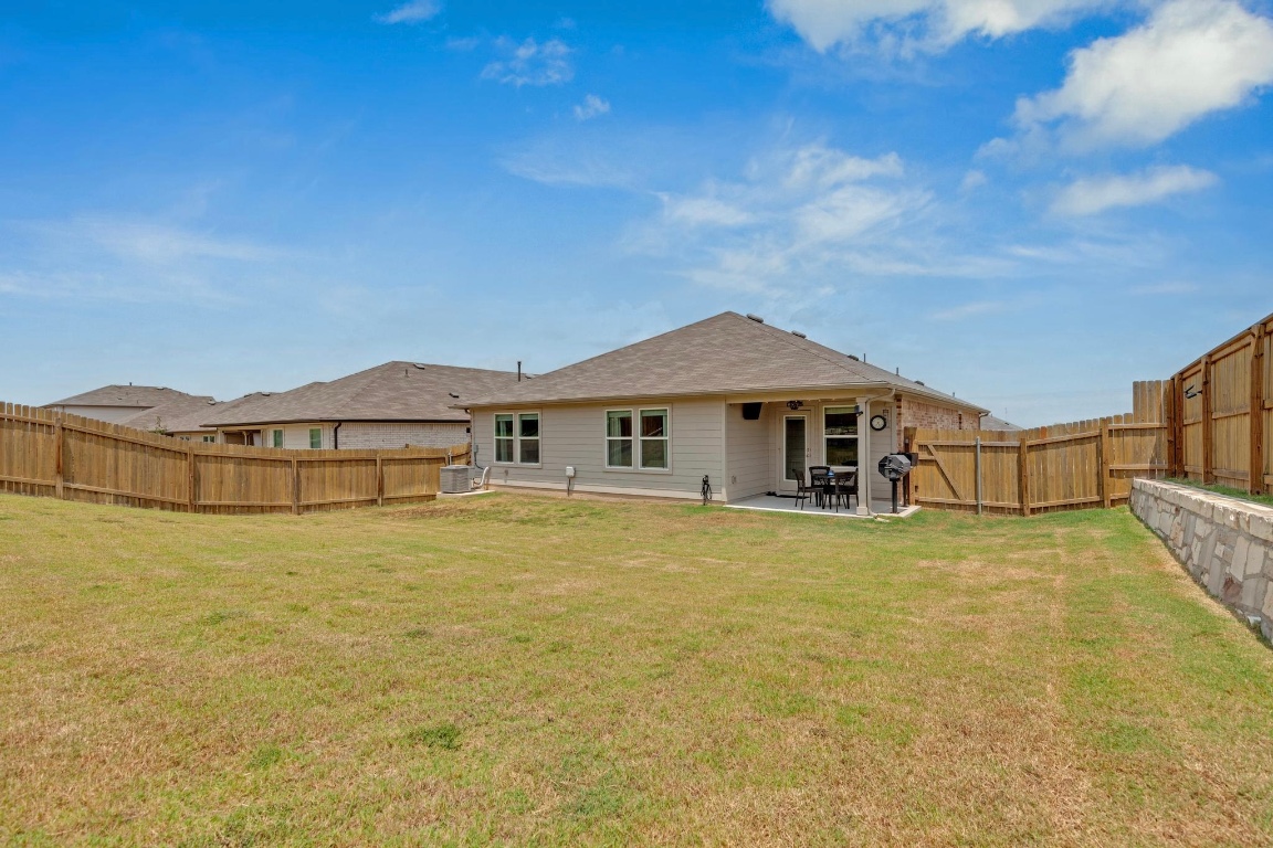 19525 Abigail Fillmore Road Manor, TX 78653 - Photo 33 of 40 Back of house with a patio and a fenced backyard