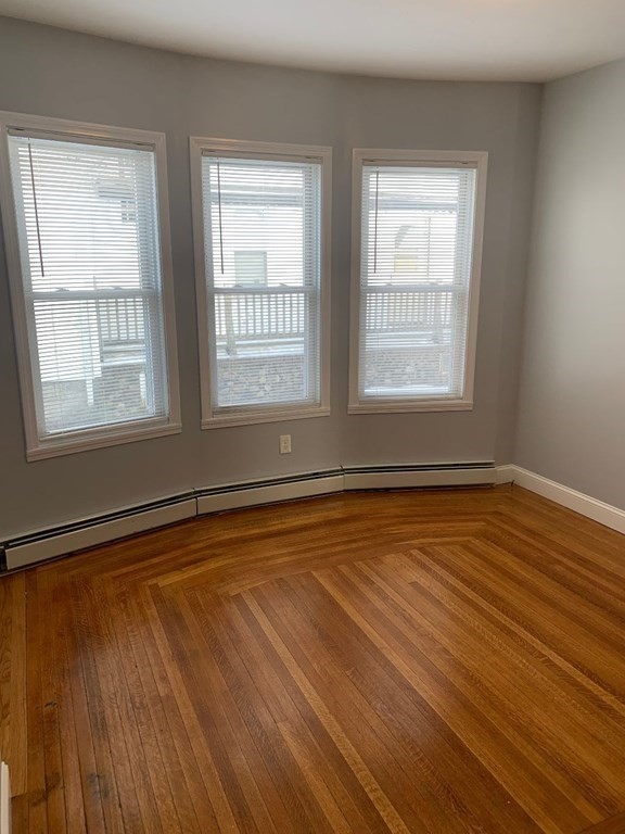 243 Bruce Street Lawrence, MA 01841 - Photo 11 of 16 a view of an empty room with wooden floor and a window