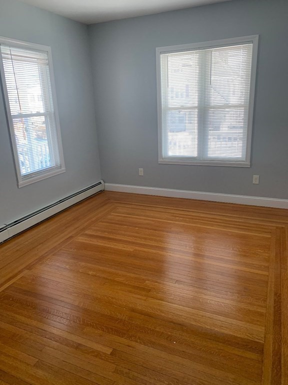 243 Bruce Street Lawrence, MA 01841 - Photo 12 of 16 a view of an empty room with wooden floor and a window