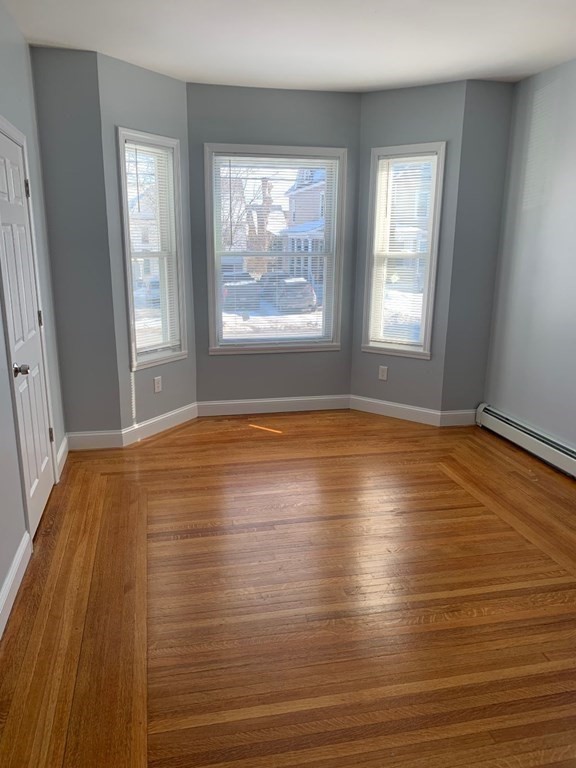 243 Bruce Street Lawrence, MA 01841 - Photo 14 of 16 an empty room with wooden floor and windows